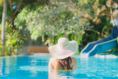 Güzel bir Asyalı kadın portresi. Mutlu bir gülümseme. Keyifli bir tatil için otel havuzunda rahatça yüzme havuzu.