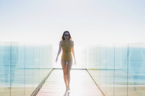 Portrait beautiful young asian woman walk with smile and look around beach sea ocean in leisure traval vacation