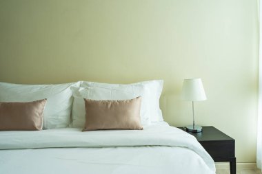 Yatak odasının iç dekorasyonunda beyaz rahat yastık.