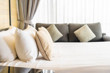 Otel odasındaki yatak odasının iç dekorasyonunda beyaz rahat yastık.