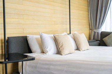 Otel odasındaki yatak odasının iç dekorasyonunda beyaz rahat yastık.