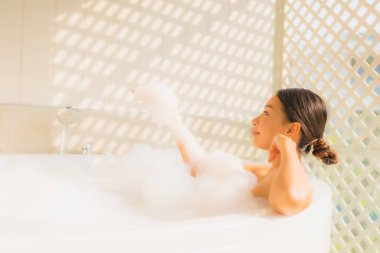 Portre genç Asyalı kadın rahatla spa konsepti için küvette banyo yap.