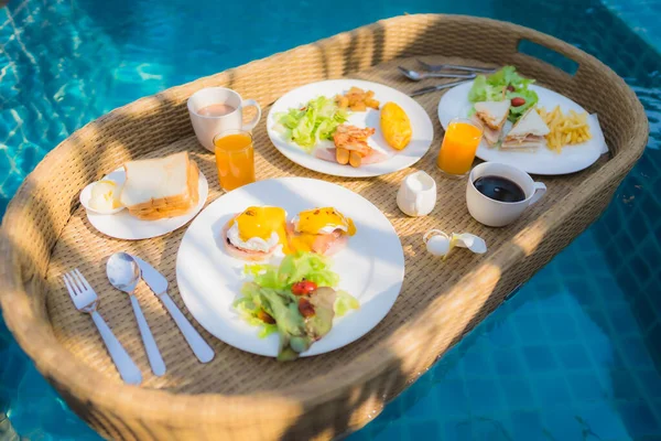 ホテルリゾートの屋外スイミングプールの周りに浮かぶ朝食 — ストック写真