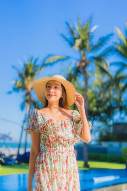 Güzel bir Asyalı kadın portresi. Mutlu bir gülümseme. Mavi gökyüzündeki tropikal deniz okyanusunda rahatla.