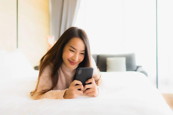 Portret Mooie Jonge Aziatische Vrouw Met Koffiebeker Mobiele Telefoon Bed — Stockfoto