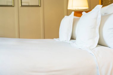 Yatak odasının iç tarafındaki yatak dekorasyonunda rahat beyaz yastık.