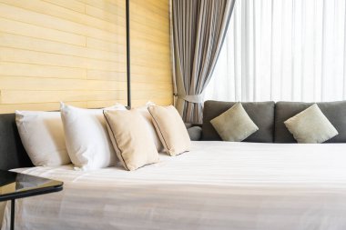 Otel odasındaki yatak odasının iç dekorasyonunda beyaz rahat yastık.