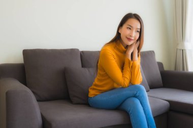 Genç Asyalı kadının portresi mutlu. Rahat ol. Koltukta gülümse.