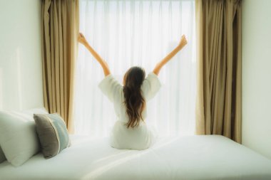 Genç Asyalı mutlu gülümseme. Yatak odasında iç tarafta rahatla.