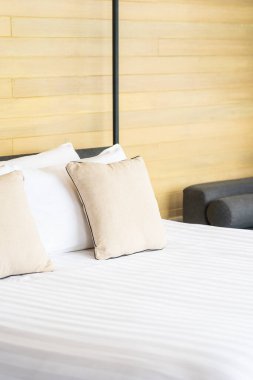 Otel odasındaki yatak odasının iç dekorasyonunda beyaz rahat yastık.