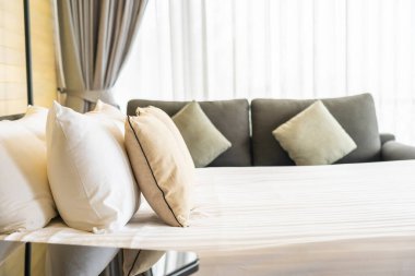 Otel odasındaki yatak odasının iç dekorasyonunda beyaz rahat yastık.