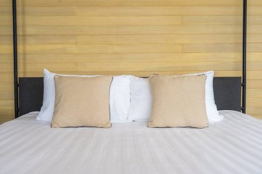 Otel odasındaki yatak odasının iç dekorasyonunda beyaz rahat yastık.