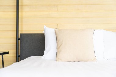 Otel odasındaki yatak odasının iç dekorasyonunda beyaz rahat yastık.