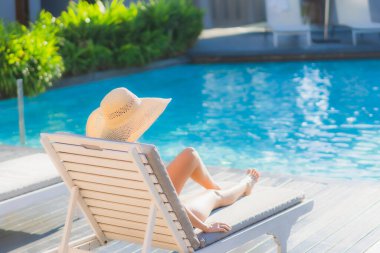 Güzel bir Asyalı kadın portresi. Mutlu bir gülümseme. Keyifli bir tatil için otel havuzunda rahatça yüzme havuzu.