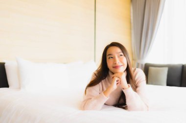 Güzel bir Asyalı kadın portresi. Mutlu bir gülümseme. Yatak odasında iç tarafta rahatla.