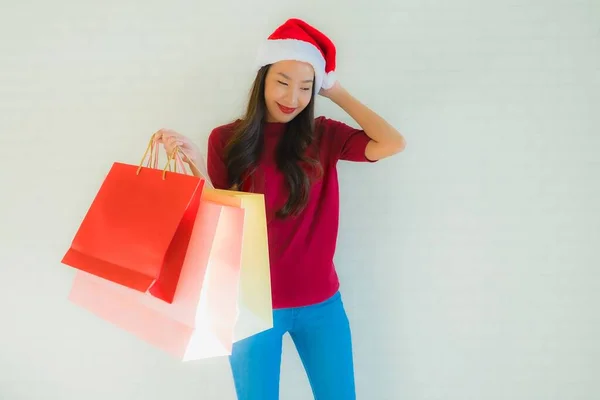 在百货商店里 亚洲年轻貌美的女性头戴圣诞礼帽 头戴购物袋 — 图库照片