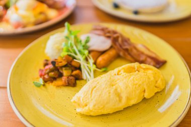 Kahvaltıda sosisli, sebzeli jambonlu omlet.