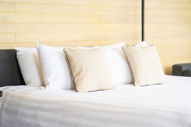 Otel odasındaki yatak odasının iç dekorasyonunda beyaz rahat yastık.