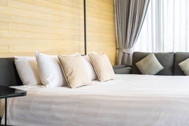 Otel odasındaki yatak odasının iç dekorasyonunda beyaz rahat yastık.