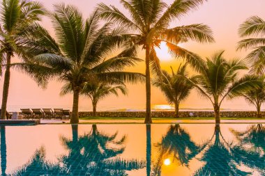Güzel doğa, açık havuz çevresindeki palmiye ağaçları oteldeki tatil beldesinde, neredeyse deniz kıyısında.