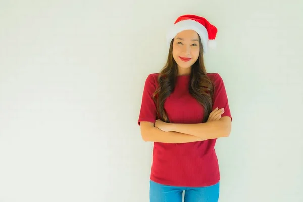 クリスマスの日にお祝いのためにサンタの帽子をかぶって肖像画の美しい若いアジアの女性 — ストック写真