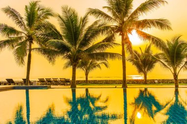 Güzel doğa, açık havuz çevresindeki palmiye ağaçları oteldeki tatil beldesinde, neredeyse deniz kıyısında.