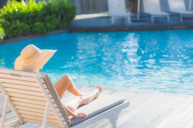 Güzel bir Asyalı kadın portresi. Mutlu bir gülümseme. Keyifli bir tatil için otel havuzunda rahatça yüzme havuzu.