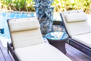 Otel tatil beldesinde yüzme havuzunda boş iskemle odası.
