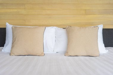 Otel odasındaki yatak odasının iç dekorasyonunda beyaz rahat yastık.