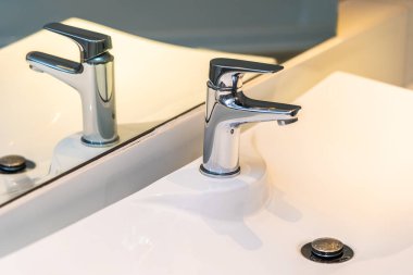 Banyo ve tuvaletin içi su ve beyaz lavabo dekorasyonu ile dolu.