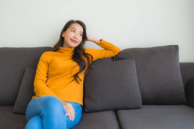 Genç Asyalı kadının portresi mutlu. Rahat ol. Koltukta gülümse.