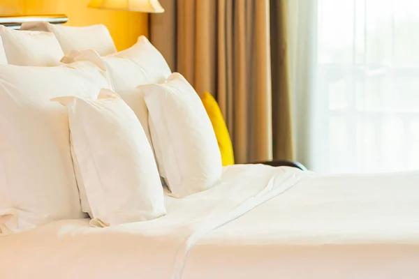 明るいランプ付きのベッドルームの装飾のインテリアの上の白い快適な枕 — ストック写真