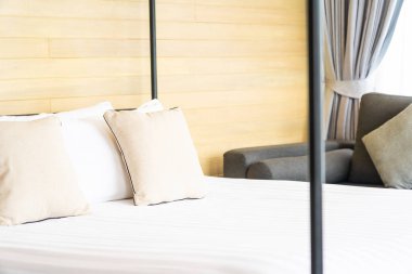 Otel odasındaki yatak odasının iç dekorasyonunda beyaz rahat yastık.
