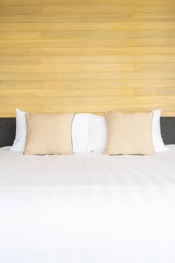 Otel odasındaki yatak odasının iç dekorasyonunda beyaz rahat yastık.