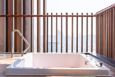 Banyo yapmak ve dinlenmek için küvet dekorasyonunda suyun üzerinde kırmızı gül çiçeği.