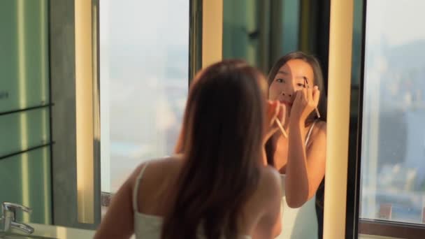 美丽的亚洲女人在家里镜子前化妆的镜头 — 图库视频影像