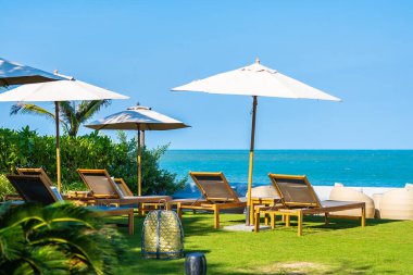 Şemsiye ve sandalye deniz kıyısında seyahat için.