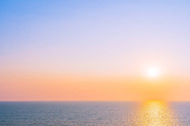 Güzel gün batımı ya da deniz kıyısı etrafında gün doğumu. Boş zamanlarında gökyüzünde bulut var.