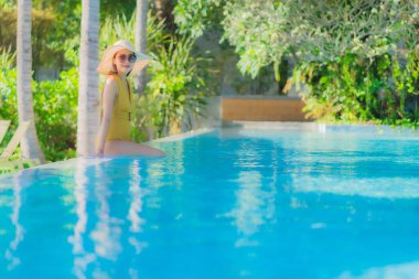 Güzel bir Asyalı kadın portresi. Mutlu bir gülümseme. Keyifli bir tatil için otel havuzunda rahatça yüzme havuzu.