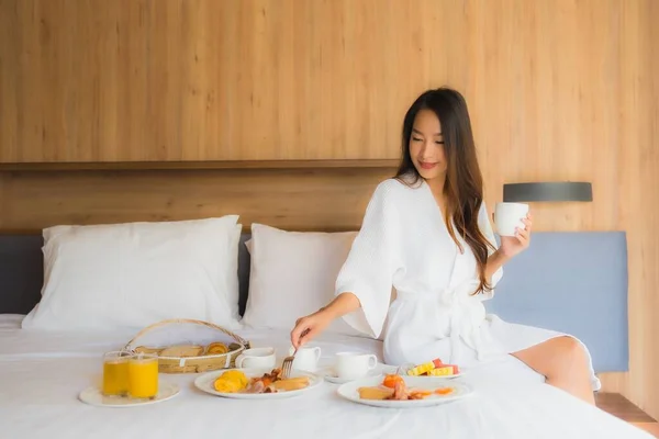 美丽动人的年轻亚洲女人快乐地享受床上早餐 — 图库照片