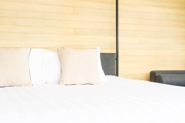 Otel odasındaki yatak odasının iç dekorasyonunda beyaz rahat yastık.