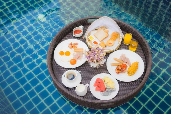 Breakfast set floating around swimming pool in hotel resort