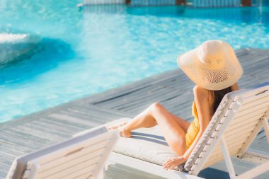 Güzel bir Asyalı kadın portresi. Mutlu bir gülümseme. Keyifli bir tatil için otel havuzunda rahatça yüzme havuzu.