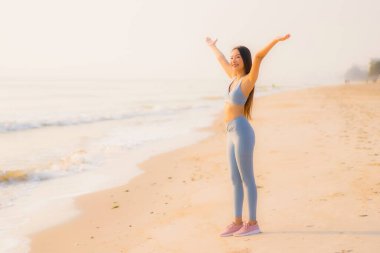 Portre sporu genç Asyalı kadın egzersiz hazırlıyor ya da sağlık için okyanusta koşuyor.
