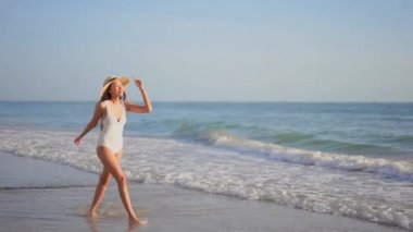 Güzel Asyalı kadının tatilde deniz kıyısındaki görüntüleri.