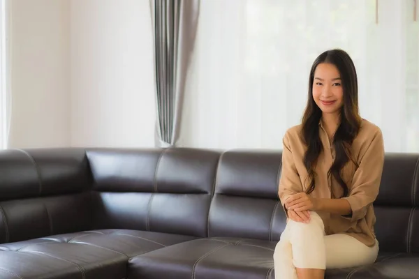 ポートレート美しい若いアジア人女性幸せな笑顔リラックス上のソファでリビングルームインテリア — ストック写真
