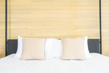 Otel odasındaki yatak odasının iç dekorasyonunda beyaz rahat yastık.