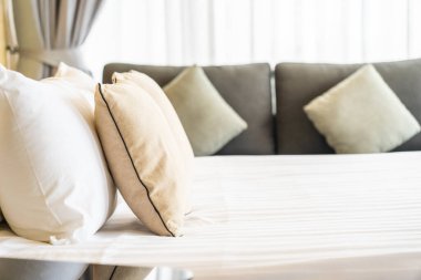 Otel odasındaki yatak odasının iç dekorasyonunda beyaz rahat yastık.