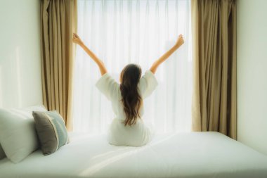 Genç Asyalı mutlu gülümseme. Yatak odasında iç tarafta rahatla.