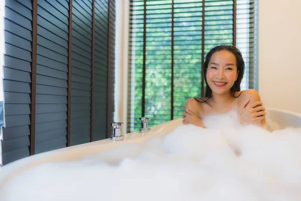 Portrait beautiful young asian woman happy smile relax take a bath in bathtub of bathroom interior